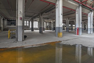 Empty production hall with puddle of water on the floor