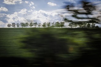 Landscape in central Germany. View from a moving train onto meadows and trees