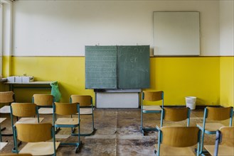Chairs standing in a classroom with blackboard of the old primary school in Trinwillershagen