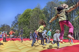 Children in bouncy castle in springtime Luitpoldpark