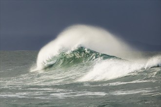 Big wave breaks in the open sea on the Breton coast near Brest