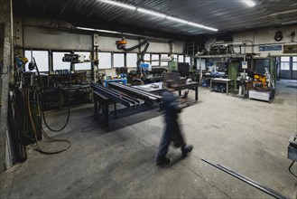 A metal worker walks in a forge in Klitten