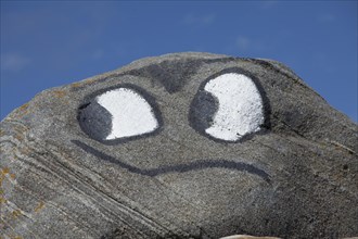 Eyes and mouth painted on rock