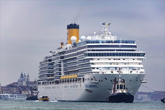 The cruise ship Costa Luminosa of the shipping company Costa Crociere sails to the cruise terminal Stazione Marittima. Meanwhile