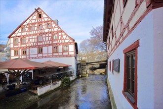 Half-timbered house Lochmuehle with mill wheel on the Grosse Blau stream in Gerbergasse