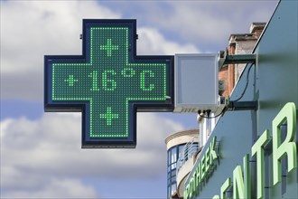 Thermometer in pharmacy screen sign displays extremely warm temperature of 16 degrees Celsius
