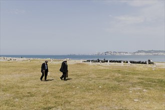 Two old men walking on the beach of Durres