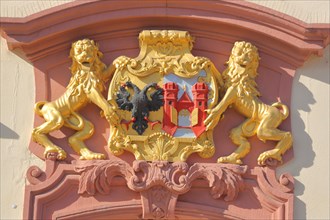 Golden town coat of arms with lion figure and double-headed eagle on the town hall