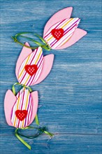 Three fabric tulips with three hearts on a blue background