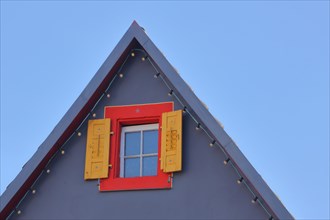 Gable with red window and yellow shutters of the restaurant Zum Andres