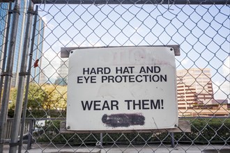 Sign at a construction site instructing workers to wear protective equipment