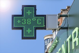 Thermometer in green pharmacy screen sign displays extremely hot temperature of 38 degrees Celsius during heatwave