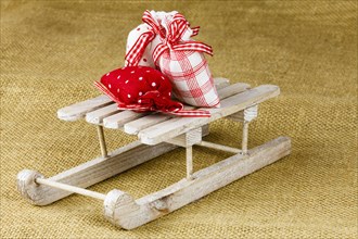 Three little bags on a wooden sledge