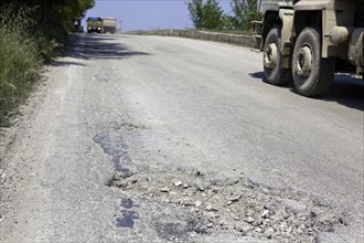 Bumpy road with pothole