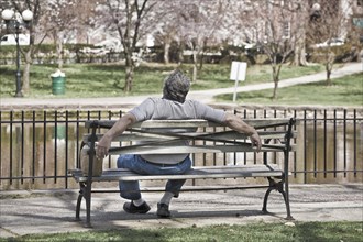 Man sitting on a bench in a city park