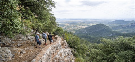 Hikers on the trail to the castle ruins of Castell Alaro