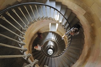 Tourist taking picture of spiral staircase inside the lighthouse Phare des Baleines on the island Ile de Re