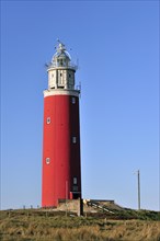 The red Cocksdorp lighthouse Eierland in the dunes on the island Texel