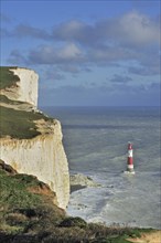 View over the eroded white chalk cliffs and lighthouse at Beachy Head