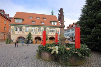 Historic town hall with wall painting and Christmas decoration with Advent wreath and Christmas tree