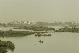 A man with a boat stands out on the Niger River in Bamako