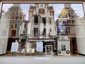 View into the shop window with reflections of gabled houses