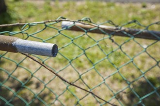 Broken railing on a chainlink fence