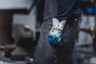 A metal worker wears work gloves