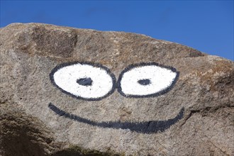 Eyes and mouth painted on rock