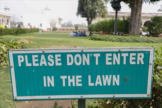Tourists ignore the sign and picnic on the lawn