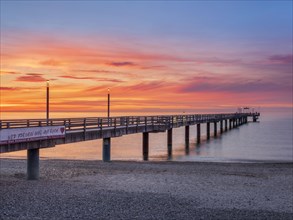 Pier on the beach of the Baltic Sea at sunset