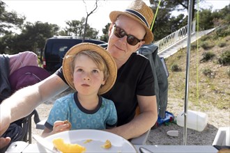 Subject: Holiday. Grandfather and grandchild sitting at the table at a campsite in Croatia