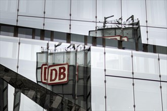 The logo of Deutsche Bahn is reflected in a glass facade in Berlin