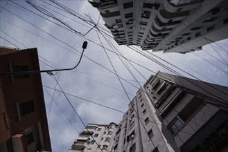 Cables loom between tall houses