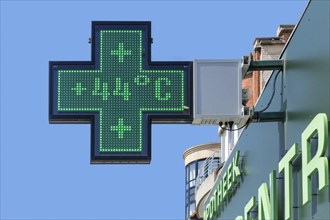 Thermometer in green pharmacy screen sign displays extremely hot temperature of 44 degrees Celsius during heatwave