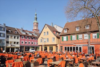 Market place with street pub and steeple of the Holy Cross Church