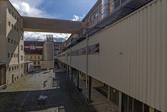 View into the company courtyard with factory buildings of a former paper mill