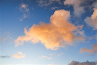 Orange spring clouds adorn the blue morning sky at sunrise