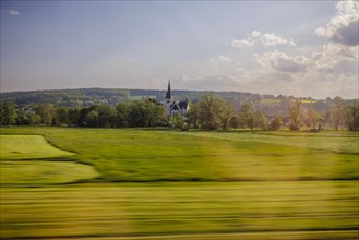 Landscape in central Germany. View from a moving train onto a church