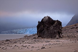 Large granite boulder on beach along the Magdalenefjord on Svalbard