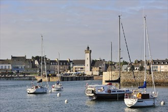 Sailing boats and lighthouse in the harbour of Roscoff