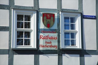 Historic town hall with two windows and town coat of arms