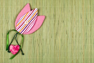 Fabric tulip with heart on green background