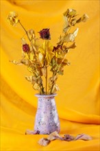 Withered bouquet of flowers against a yellow background