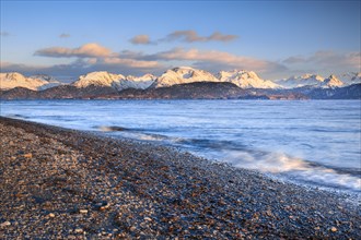 Evening atmosphere at Homer Spit with view over the stone beach and Kachemak Bay to the Kenai Mountains in the warm evening light in the background