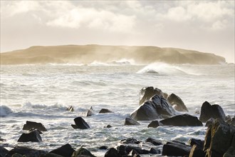 Atmospheric coastal landscape at sunrise on a rocky beach near Reiff on the west coast of Scotland
