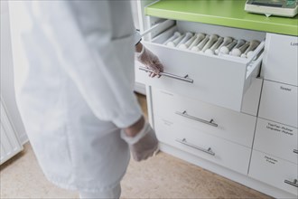 An employee opens a drawer with pistols in the prescription
