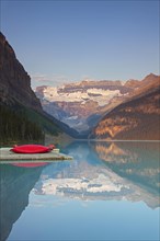 Red canoes at glacial Lake Louise with Victoria glacier