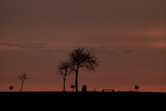 Two walkers silhouetted against the setting sun
