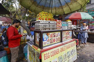 Omelette street vendor with paytm logo for cashless payment at his stall in Paharganj